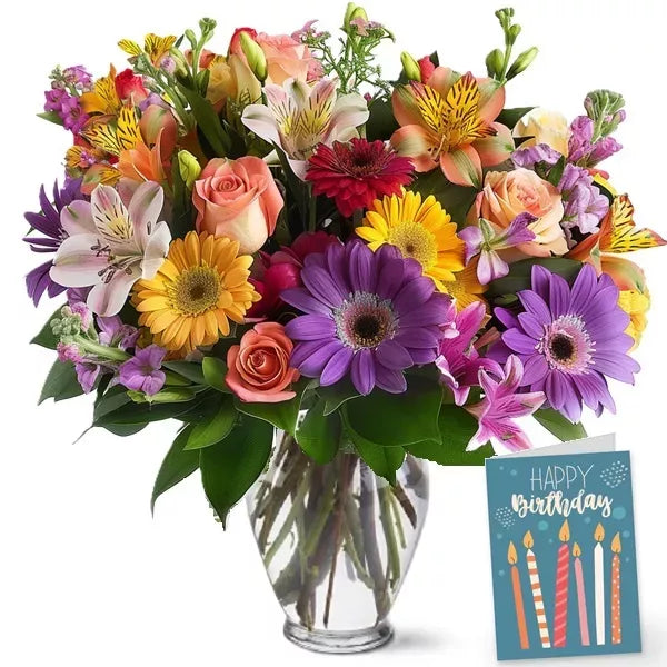 A vibrant bouquet of mixed flowers in a vase with a &#39;Happy Birthday&#39; card.
