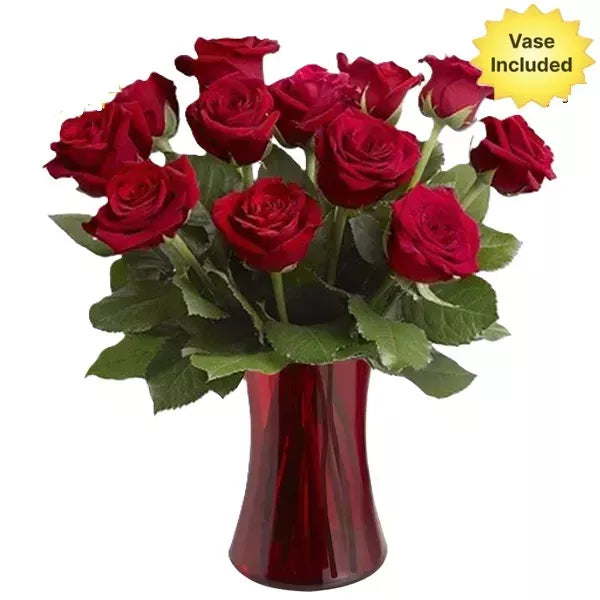 A bouquet of red roses in a red vase with a &quot;Vase Included&quot; label.