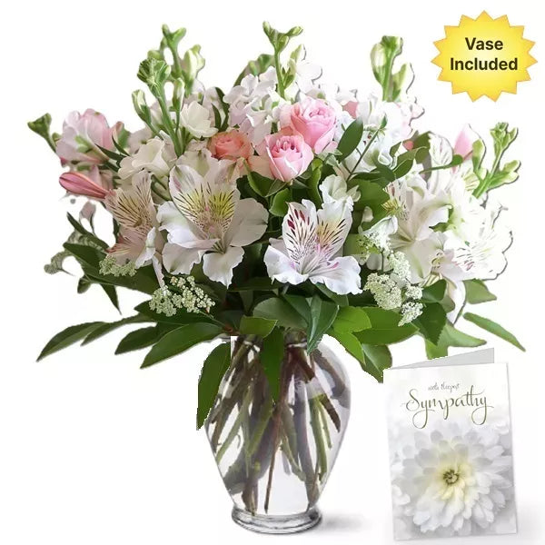 A bouquet of pink roses and white alstroemeria in a vase with a &quot;With Sympathy&quot; card.